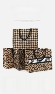 Macro detail of jute tote bags featuring leopard, zebra, and houndstooth prints with rope handles
