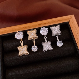 Nahaufnahme von vergoldeten und versilberten Blumenohrringen mit Zirkonia auf Samt