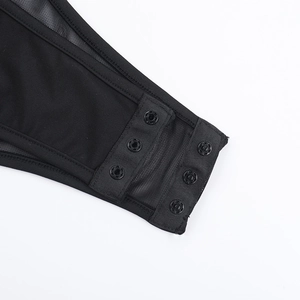 Detail view of the black mesh fabric with three snap button closures on the bodysuit