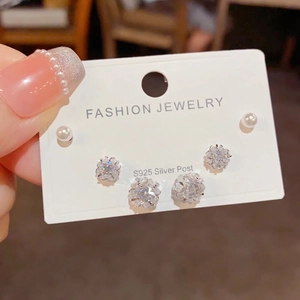 Close-up of S925 silver needle earring set with sparkling zircons and white pearls