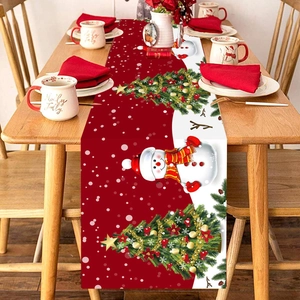 Christmas table runner with snowman and tree patterns on a rustic wooden dining table