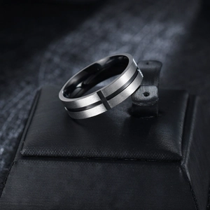Close-up of men's brushed stainless steel cross ring on a black jewelry display
