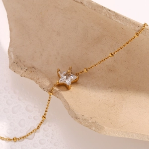 Close-up of 18K gold plated chain bracelet with micro-paved star zircon on stone