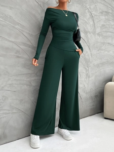 Detail of a dark green two-piece lounge set with long-sleeved top and wide-leg trousers