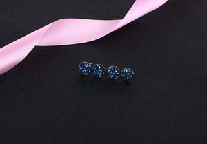 Macro shot of S925 silver stud earrings with deep blue and teal crystal druzy texture