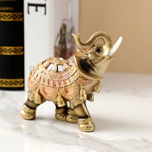 Close-up of golden elephant statue with jeweled details on a marble surface