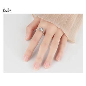 Close-up of rotatable silver sunflower ring with center stone worn on index finger