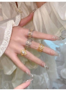 Gros plan de bagues fleurs plaquées or avec zircons portées pour un look vintage de luxe