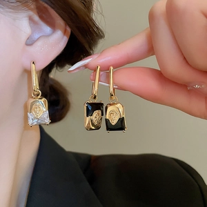 Detail of vintage lion head earrings with gold plating and cubic zirconia inlay