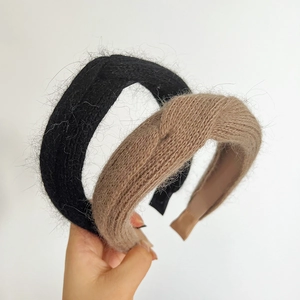 Detailed close-up of khaki and black knitted plush headbands with soft fuzzy texture