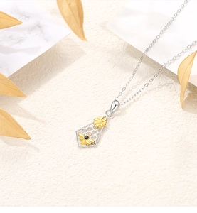 Close-up of S925 silver honeycomb necklace with golden bee and flower pendant detail