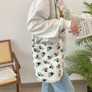 Detail of soft white plush shoulder bag with blue floral pattern for autumn and winter