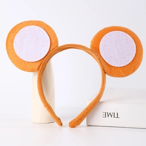 Detailed view of plush orange animal ears headband on minimalist display props
