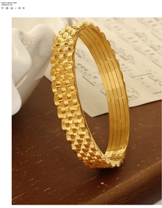 Macro detail of gold-plated watchband textured wide bracelet on a minimalist background