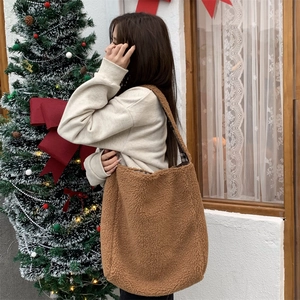 Detailed view of brown teddy fleece tote bag with inner plaid lining in a cozy festive setting