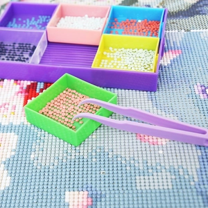 Diamond painting kit with colorful sorting trays and purple tweezers for DIY crafts