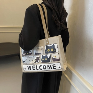 Minimalist beige cat tote bag with Welcome print carried by a model in a side view