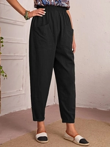 Detail view of black cotton linen tapered trousers with elastic waist and side pockets