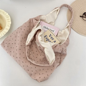 Detail of pink floral corduroy tote bag showing spacious interior with book and lining