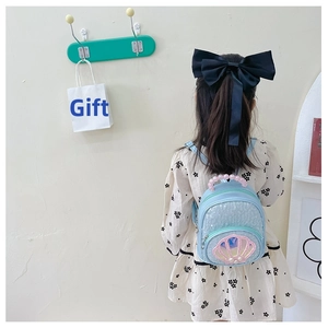 Detail of blue sequined children's backpack with shell patch and pearl handle accents
