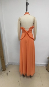 Dettaglio della vita arricciata e schiena scoperta sul vestito lungo in chiffon arancione