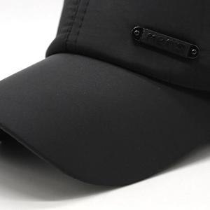 Close-up of black baseball cap showing texture and MENS metal logo plaque detail