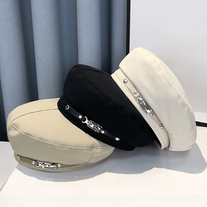 Three stylish beret hats in beige, black, and white with leather strap and metal buckle