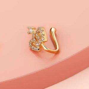 Detail of golden crown ear cuff featuring shimmering cubic zirconia on pink pedestal