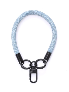 Close-up of blue denim wrist strap with black metal rings and swivel snap hook clasp