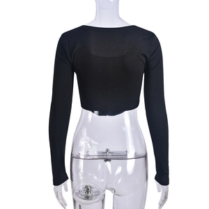 Gros plan de la texture en maille côtelée noire sur le dos du crop top à manches longues