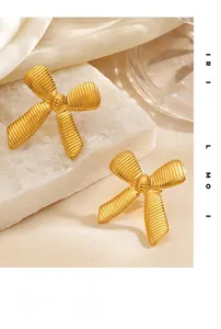 Detailed view of 18K gold plated bow earrings with vertical striped metal texture