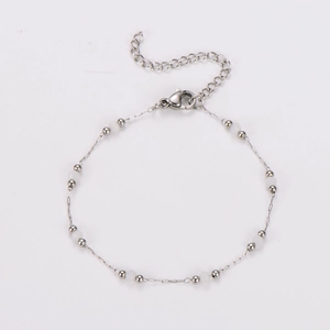 Close-up of silver beaded chain bracelet with small white beads and lobster clasp