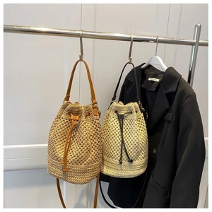 Detail of straw bucket bags with leather straps in brown and beige woven textures
