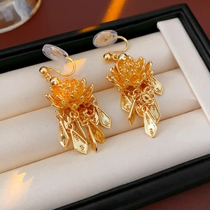 Detailed view of gold lotus leaf tassel earrings in a jewelry box for a luxury look