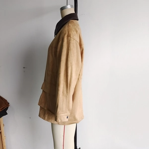 Detail of camel suede long coat featuring contrast collar and large functional pockets