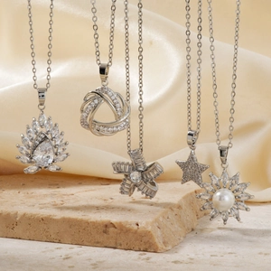 Elegant silver geometric jewelry set with lotus and star pendants on silk background