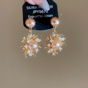 Vista macro di orecchini a fiore in zircone placcati oro 18K con perle e perno in argento