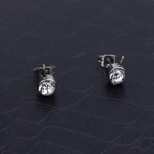 Sparkling round cubic zirconia stud earrings in silver stainless steel on dark texture