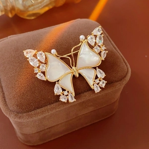 Macro shot of 18k gold plated butterfly brooch with mother of pearl on velvet case