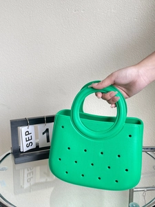Gros plan du sac de plage en EVA vert vif avec motifs perforés et poignée ronde