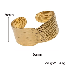 Detail view of 30mm wide golden stainless steel bangle with irregular ripple texture