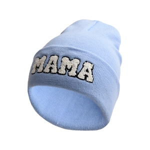Close-up of light blue knitted beanie with white MAMA towel embroidery on folded cuff