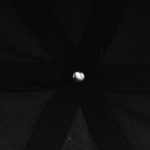 Macro shot of the black washed cotton cap's internal structure and silver metal rivet