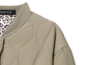 Detail of olive quilted jacket featuring ribbed collar and leopard print lining detail