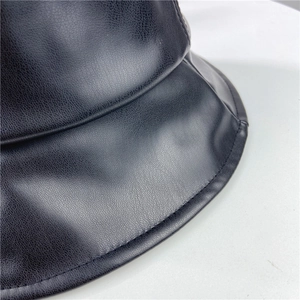 Close-up of black PU leather bucket hat showing textured finish and stitching details