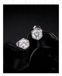 Macro shot of hexagonal moissanite stud earring on black leather texture