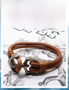 Macro shot of men's leather braided bracelet with antique silver anchor clasp detail