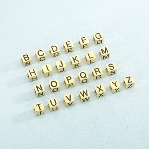 Close-up of golden stainless steel square letter beads for DIY bracelet jewelry making