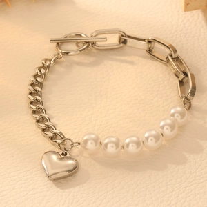Detail of silver heart pendant and toggle clasp on mixed pearl and link chain bracelet