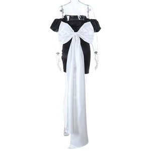 Détail de la robe mini en satin noir avec un grand nœud en soie blanche au dos élégant